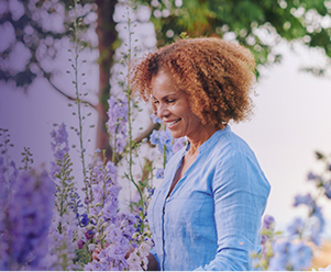 Woman smiling surrounded by flowers
